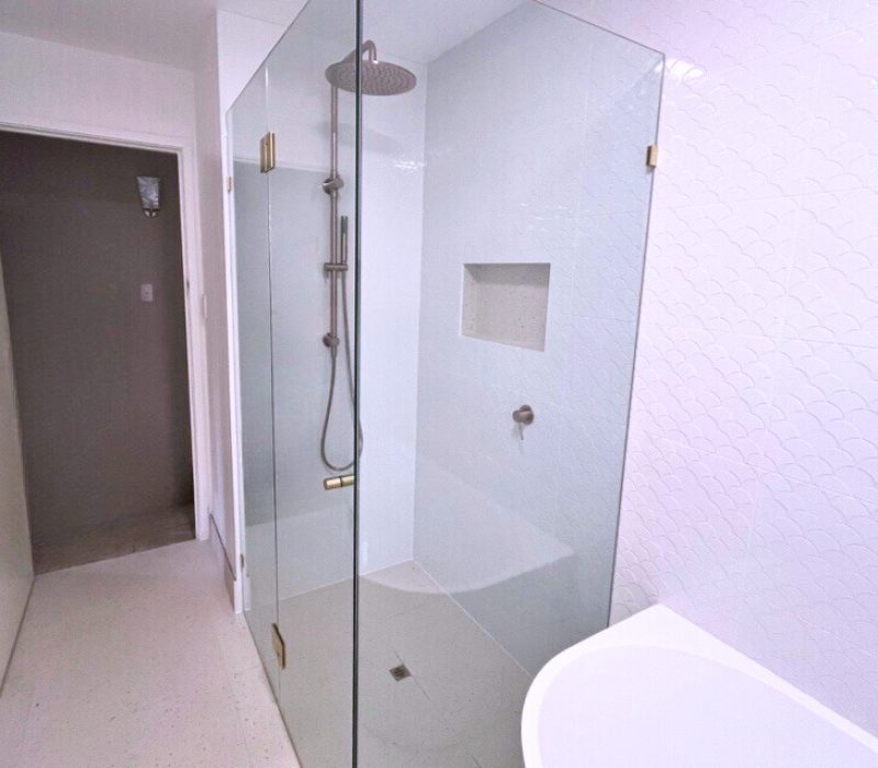 Walk-in shower with frameless glass, rainfall showerhead and brass fittings