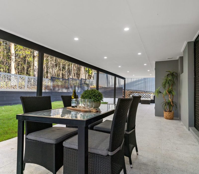 Covered patio with outdoor dining area and privacy fencing