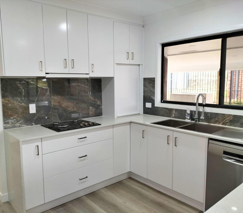 Modern kitchen with wraparound laminate benchtops and gloss white cabinetry