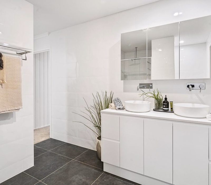 Modern white bathroom with double vanity and vessel sinks