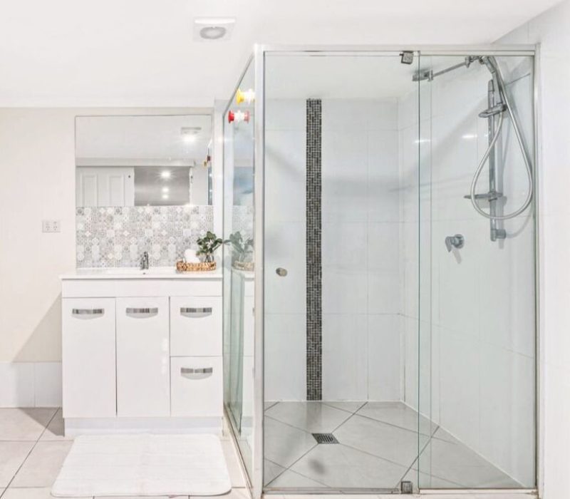 Bathroom with glass shower and mosaic tile feature strip