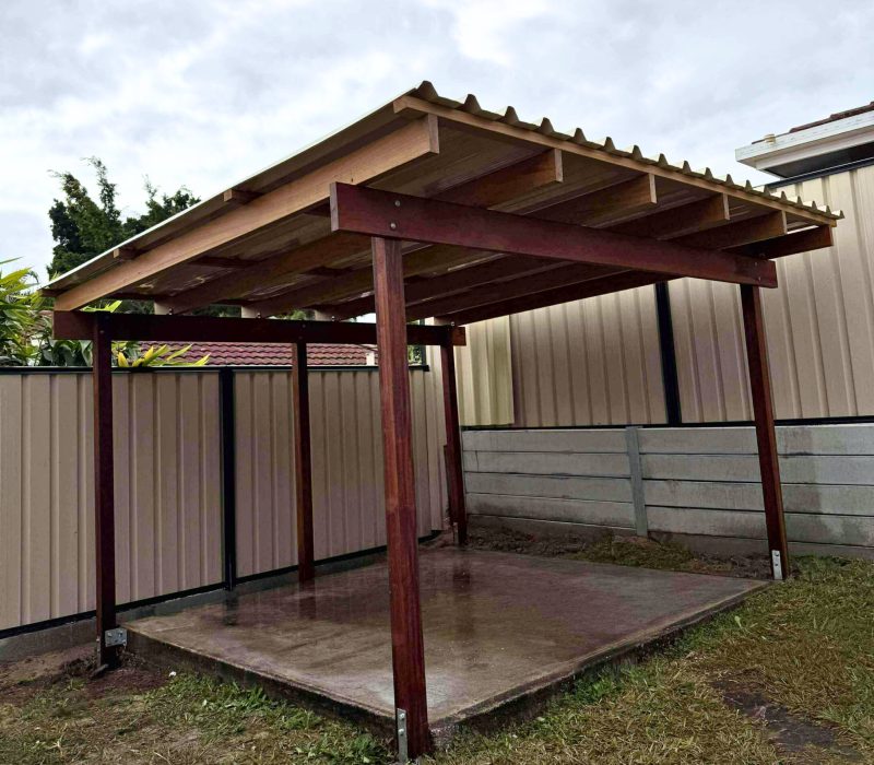 Outdoor timber pergola with corrugated roofing on a concrete slab, built in a residential backyard