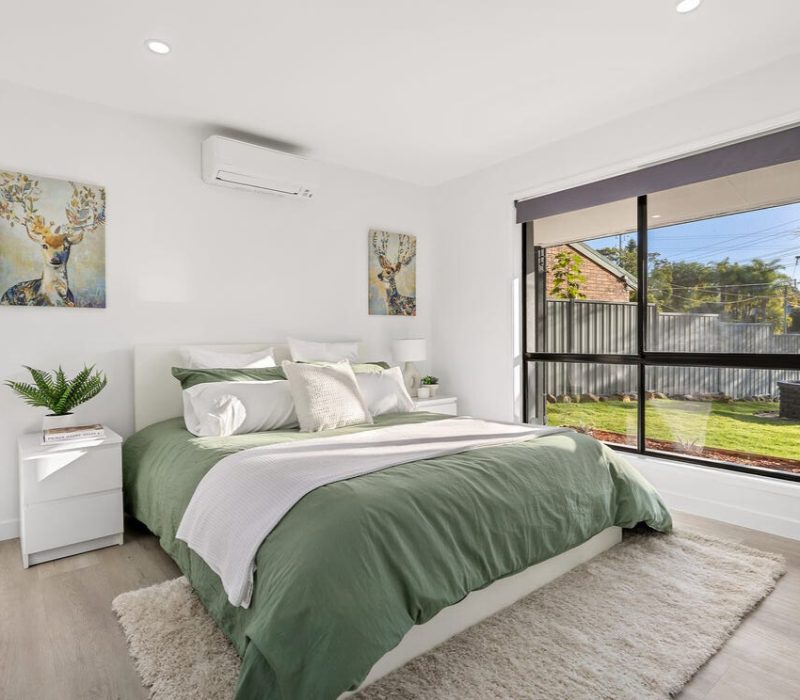 Bright bedroom with green linen and large garden-facing window